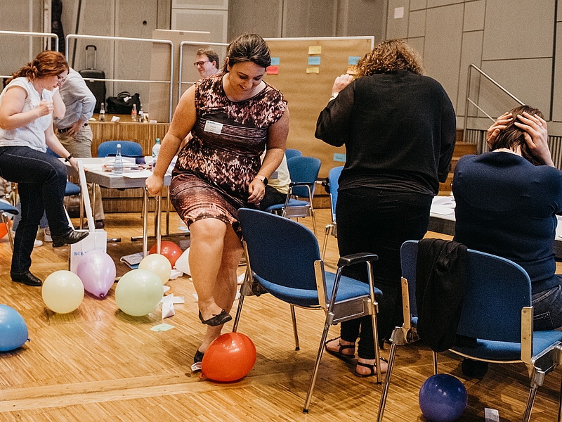 Eine Teilnehmerin im Registered Scrum Master Kurs zertritt einen aufgeblasenen Luftballon